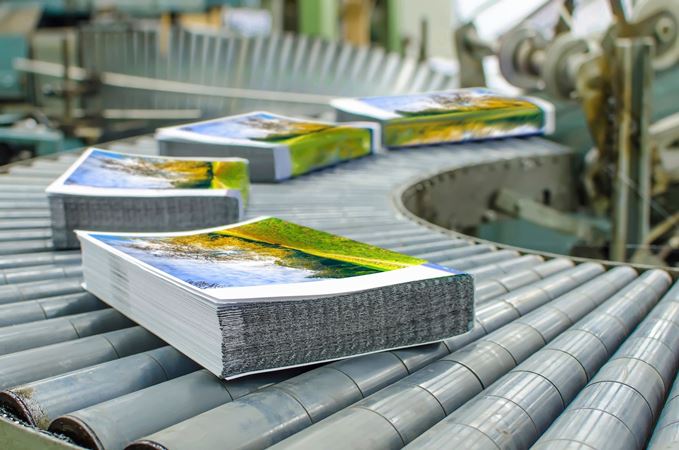 A conveyor belt with several books on it.